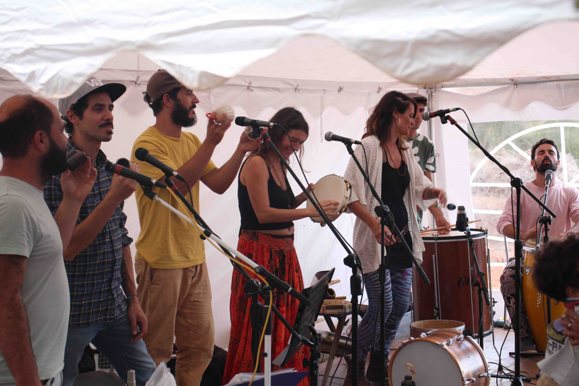 Banda ao vivo debaixo de uma tenda branca no festival