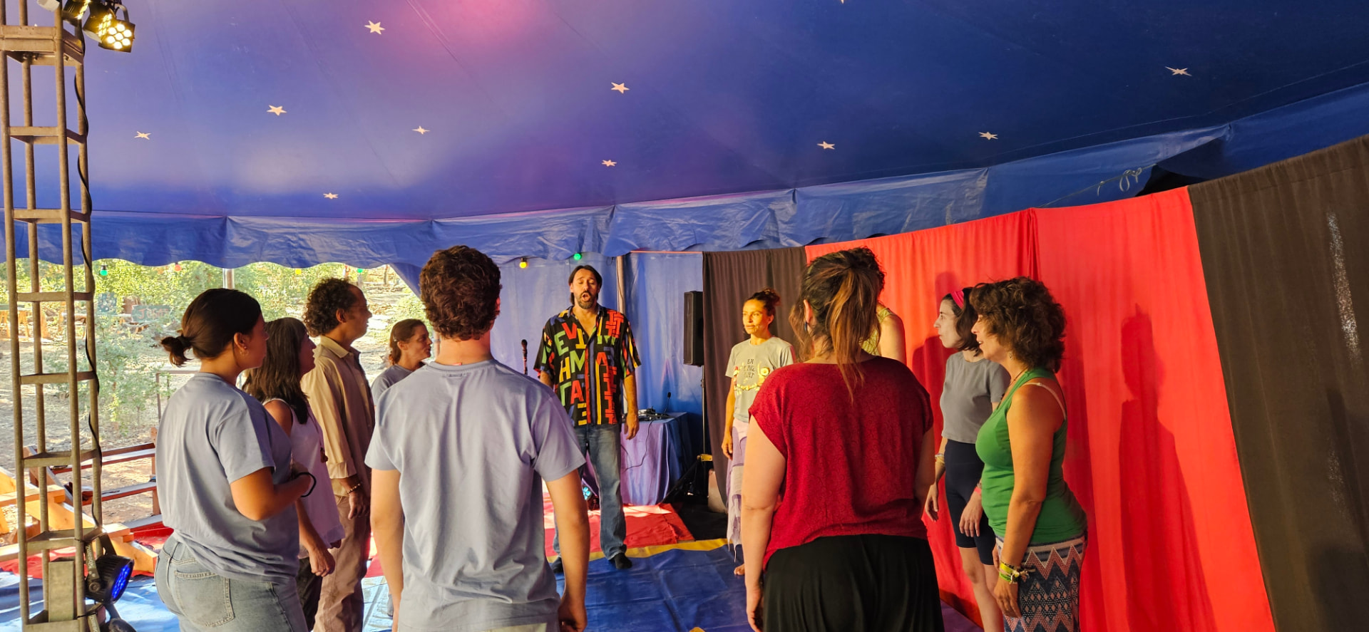 Grupo de participantes numa tenda azul com estrelas