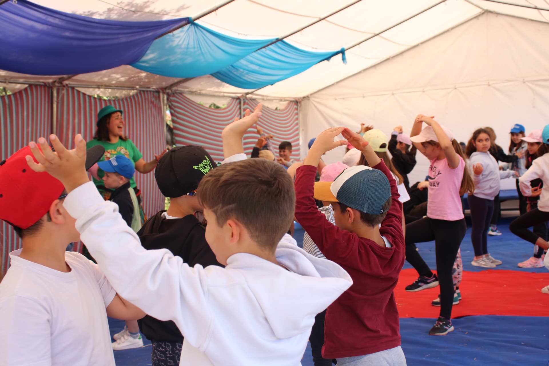 Grupo de crianças numa oficina criativa dentro de uma tenda de circo