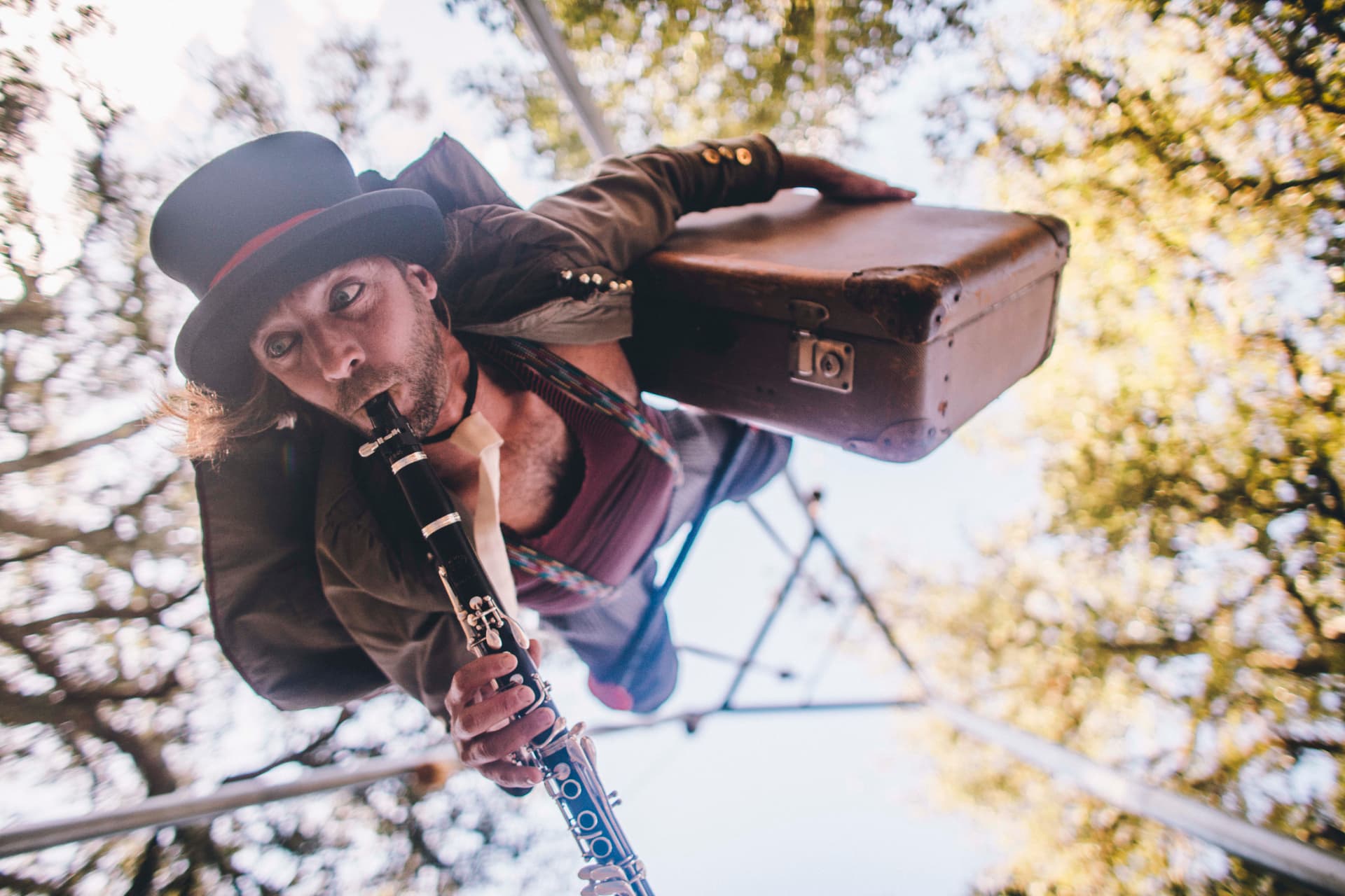 Músico a tocar clarinete em altura, entre as copas das árvores