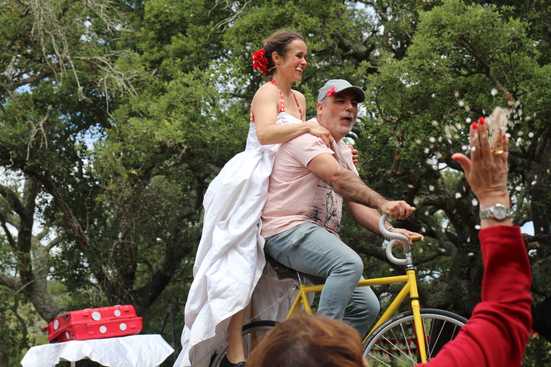 Artistas em cena sobre uma bicicleta amarela no meio da floresta